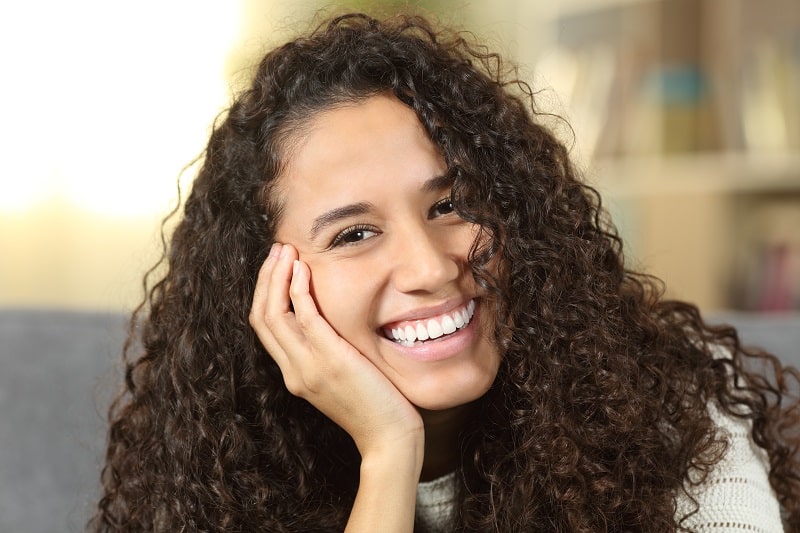 Happy woman showing perfect smile at home